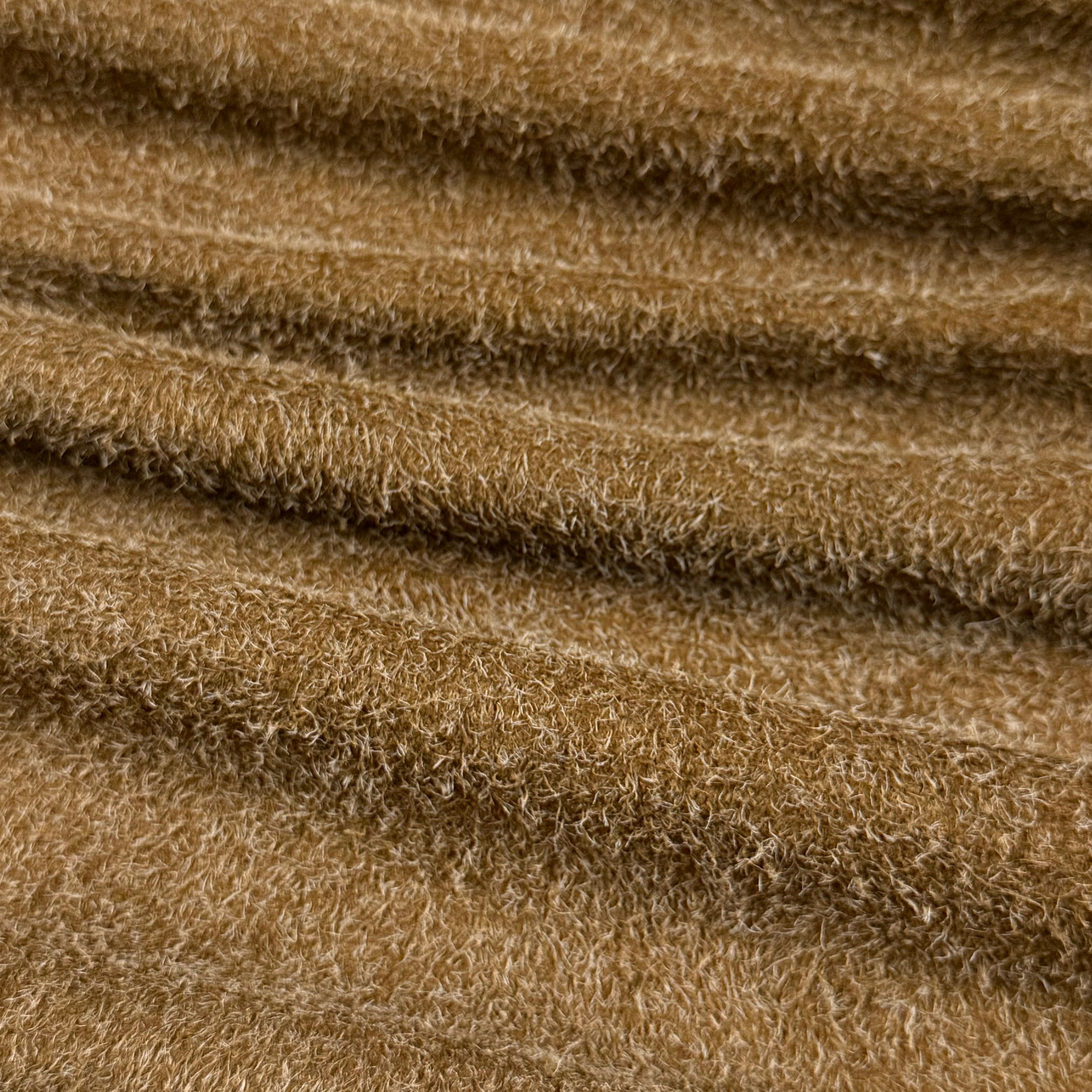 Close-up of a wavy, textured Hairy Calf Suede Bend in a warm brown color with shaggy fibers.