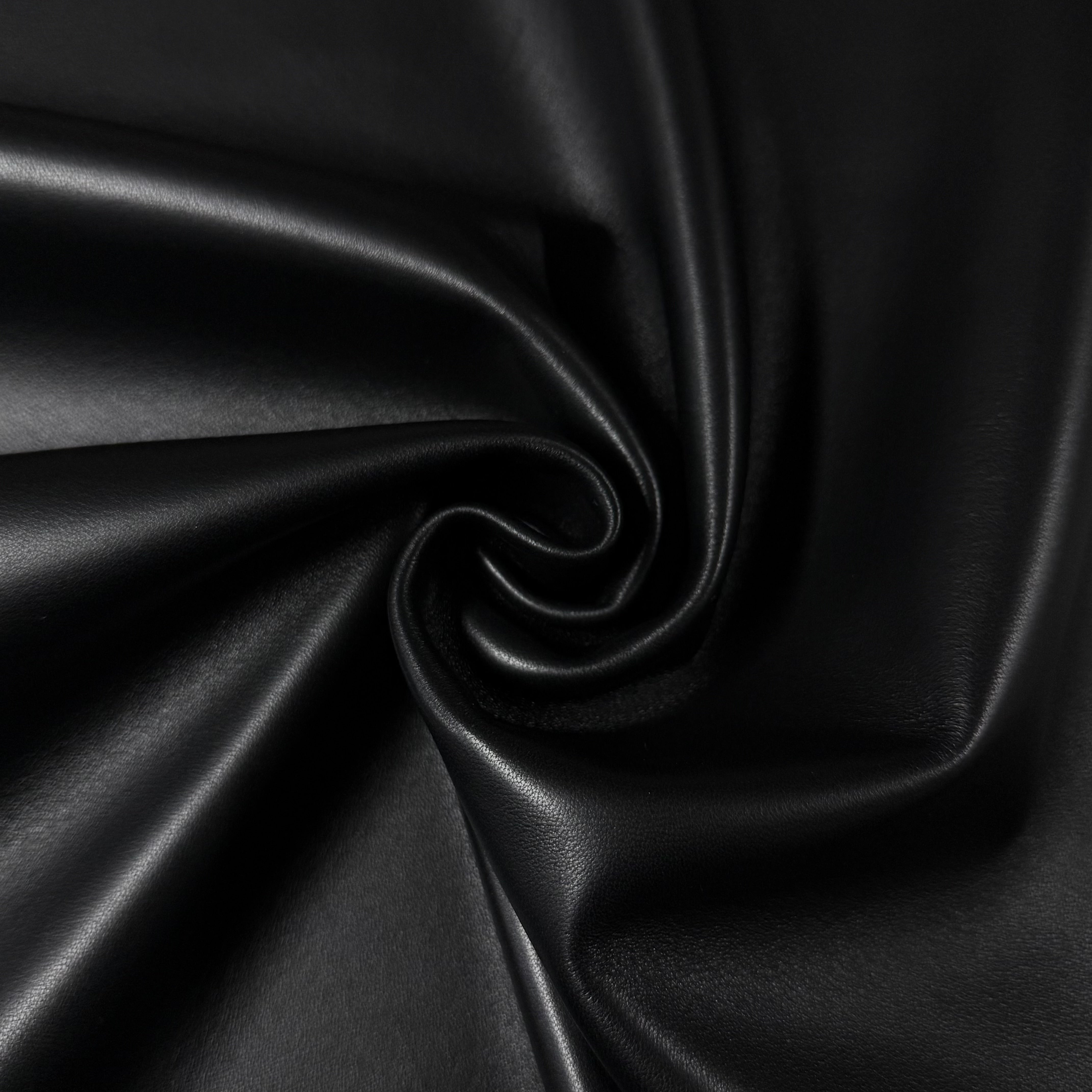 Luxury Aniline Lamb Nappa 2 oz leather in black, featuring a smooth, soft-touch texture with elegant, swirling folds.