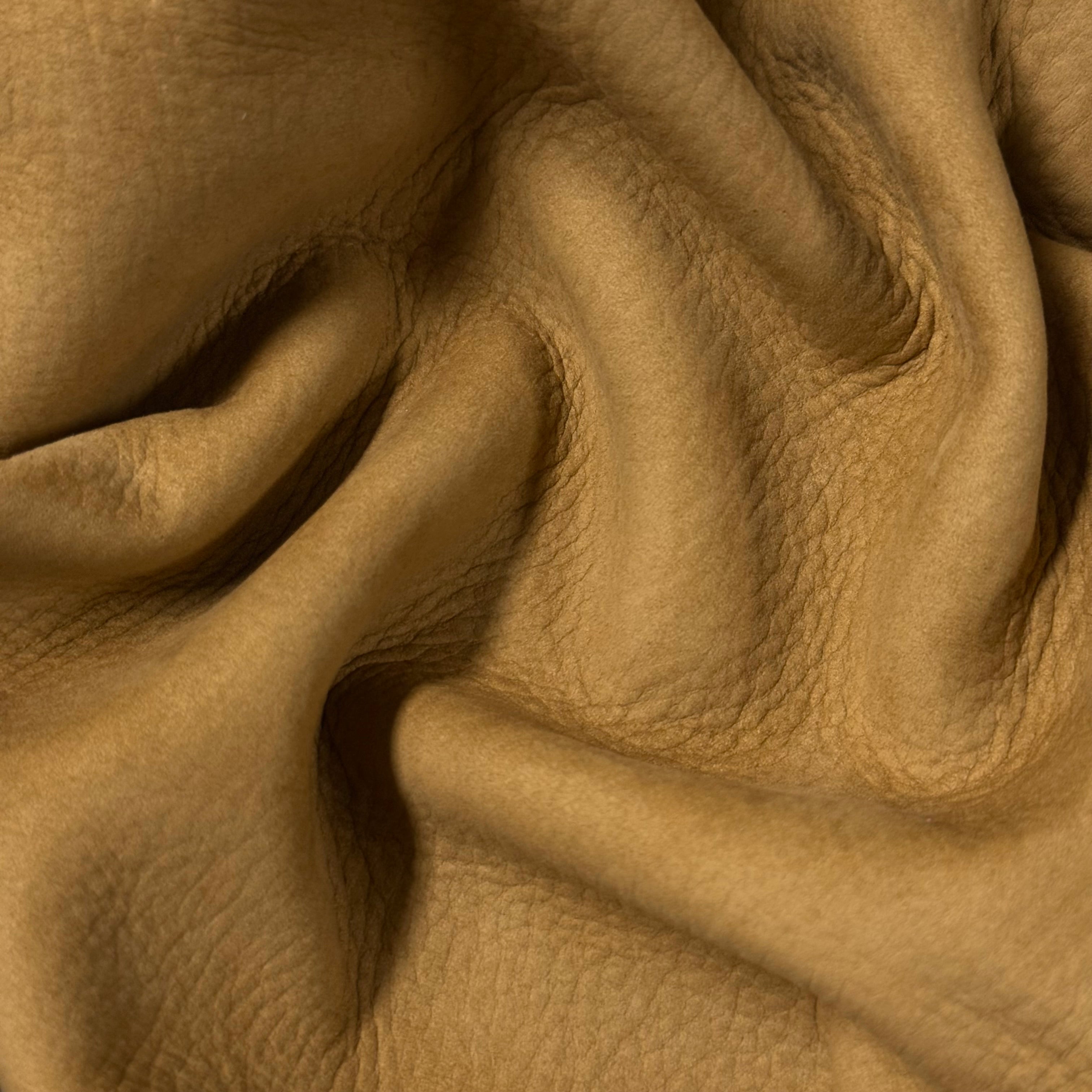 Tan premium top grain nubuck cowhide leather, 3-4 oz weight, featuring a soft, textured, and folded matte surface.