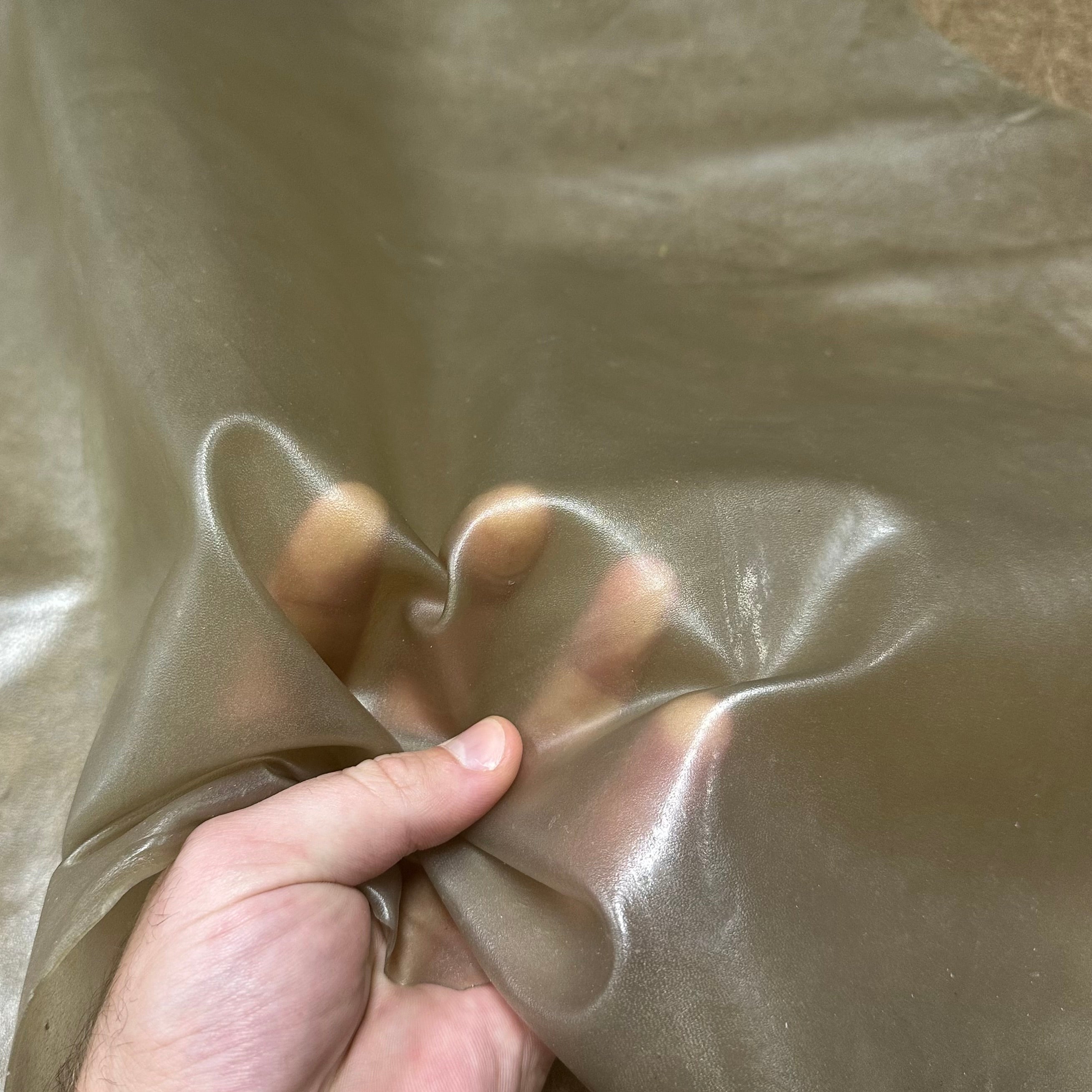Transparent Lamb Leather in Smoke, 1.5 oz, showing a thin, flexible, and translucent material held by a hand.